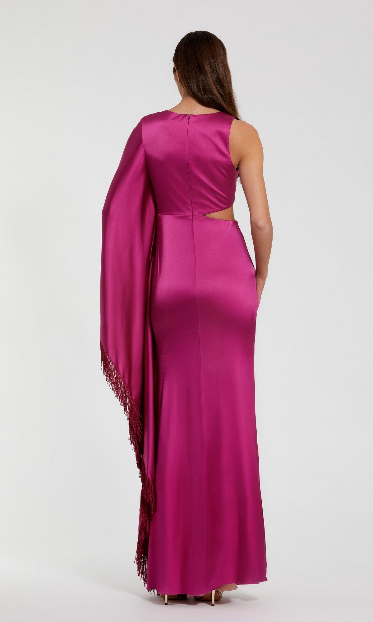 A woman faces away, wearing the Mac Duggal 49898 long formal dress in magenta charmeuse, featuring a sleeveless design, side cutout, and a matching shawl draped over one shoulder, set against a plain background.
